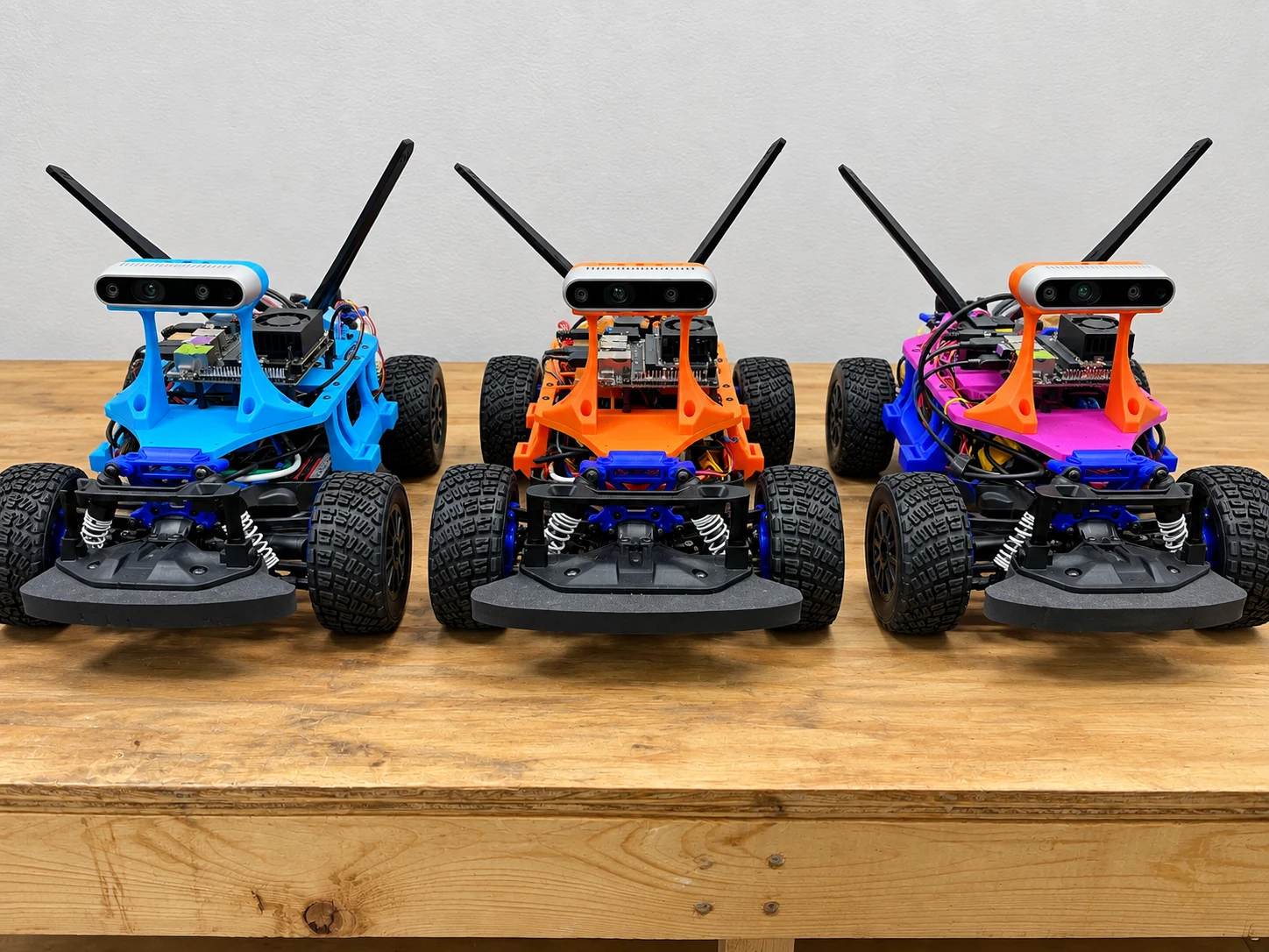 Three colorful GOAT RACER builds lined up on a workbench
