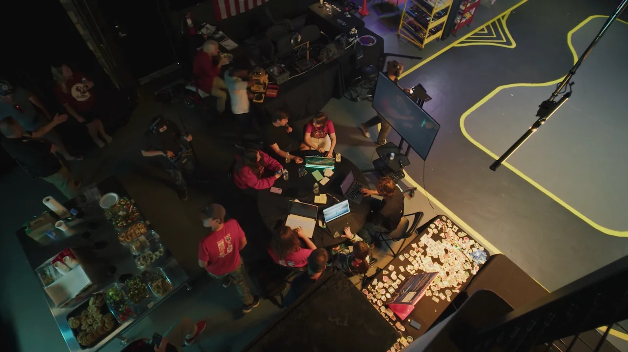 Teams working together beside a GOAT RACER course at an in-person workshop